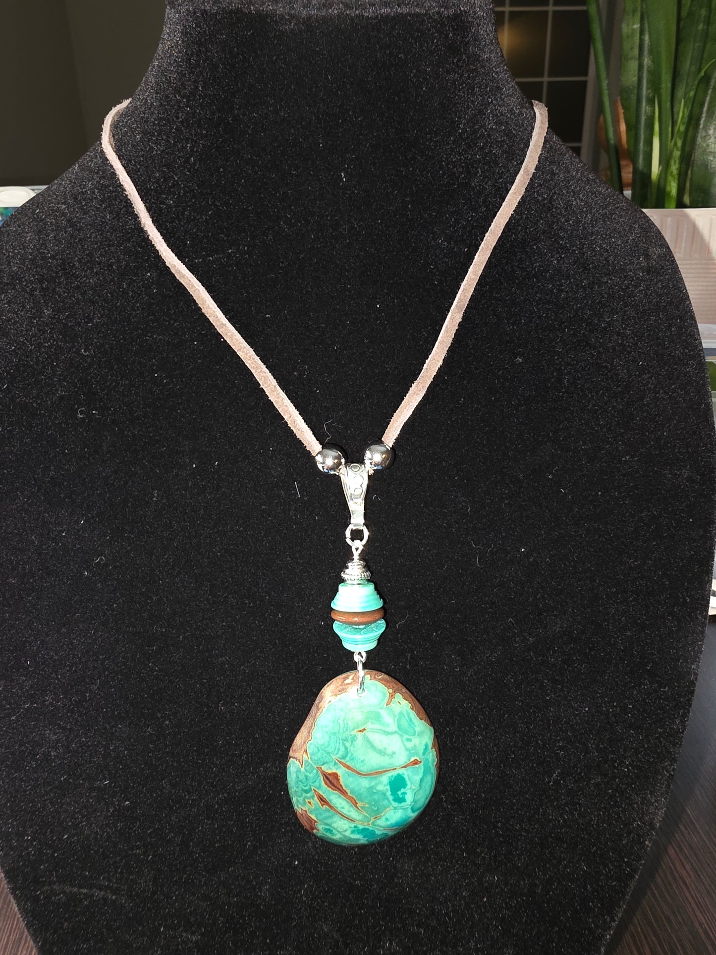 Necklace with a large turquoise bead on a black background