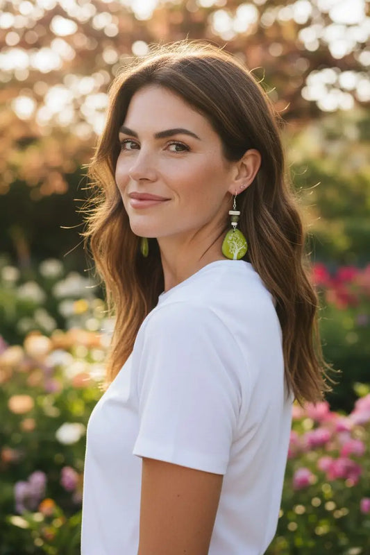 Green leaf-shaped sweet pea earrings with metallic accent made from laser engraved tagua slice material