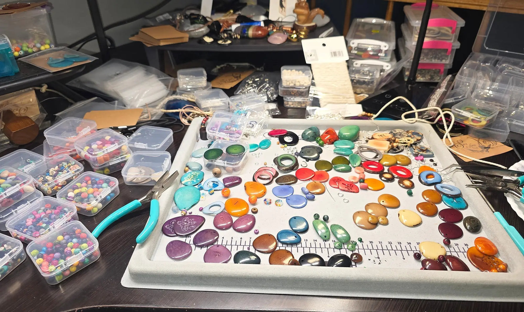 A tray of colorful polished beads in various shapes and sizes highlighting handmade adornment artistry