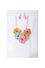 Vibrant becca handmade flower bib necklace with pink orange teal petals and red gemstone centers in tagua material