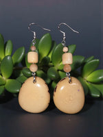 Beige tan polished tagua oval earrings with subtle wood grain pattern and dark speckles plastic free vegan from rainforest