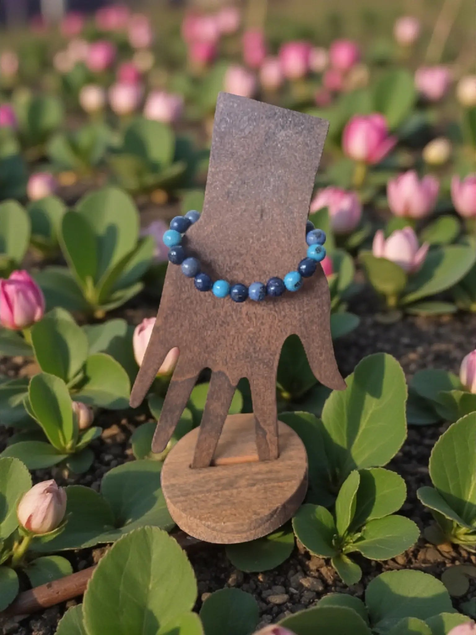 Delicate blue and dark navy forest seed bracelet displayed on wooden hand stand fair trade from Ecuador
