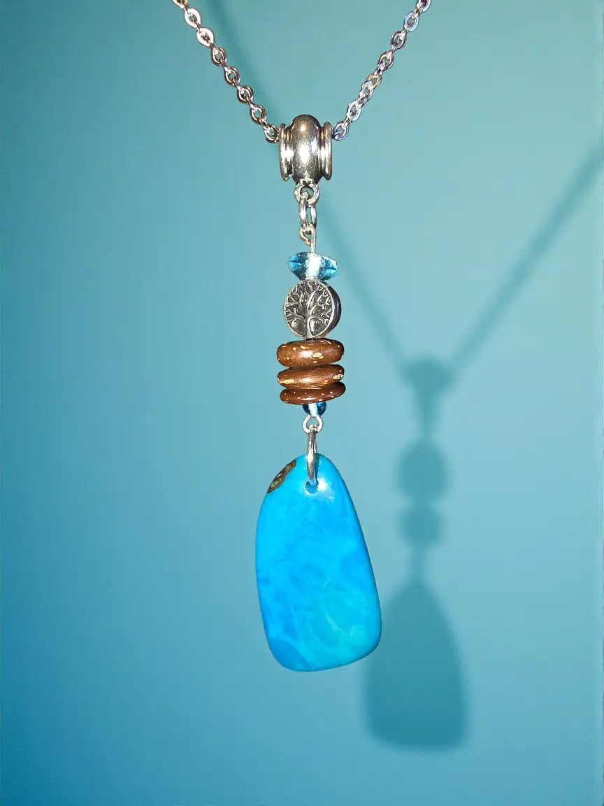 A vibrant turquoise pendant fair trade jewelry gift with silver-toned chain and decorative beads eco-friendly design