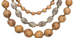 A 3-strand idra necklace with tan acai berries, tagua nut beads, and silver-toned oval metallic plates
