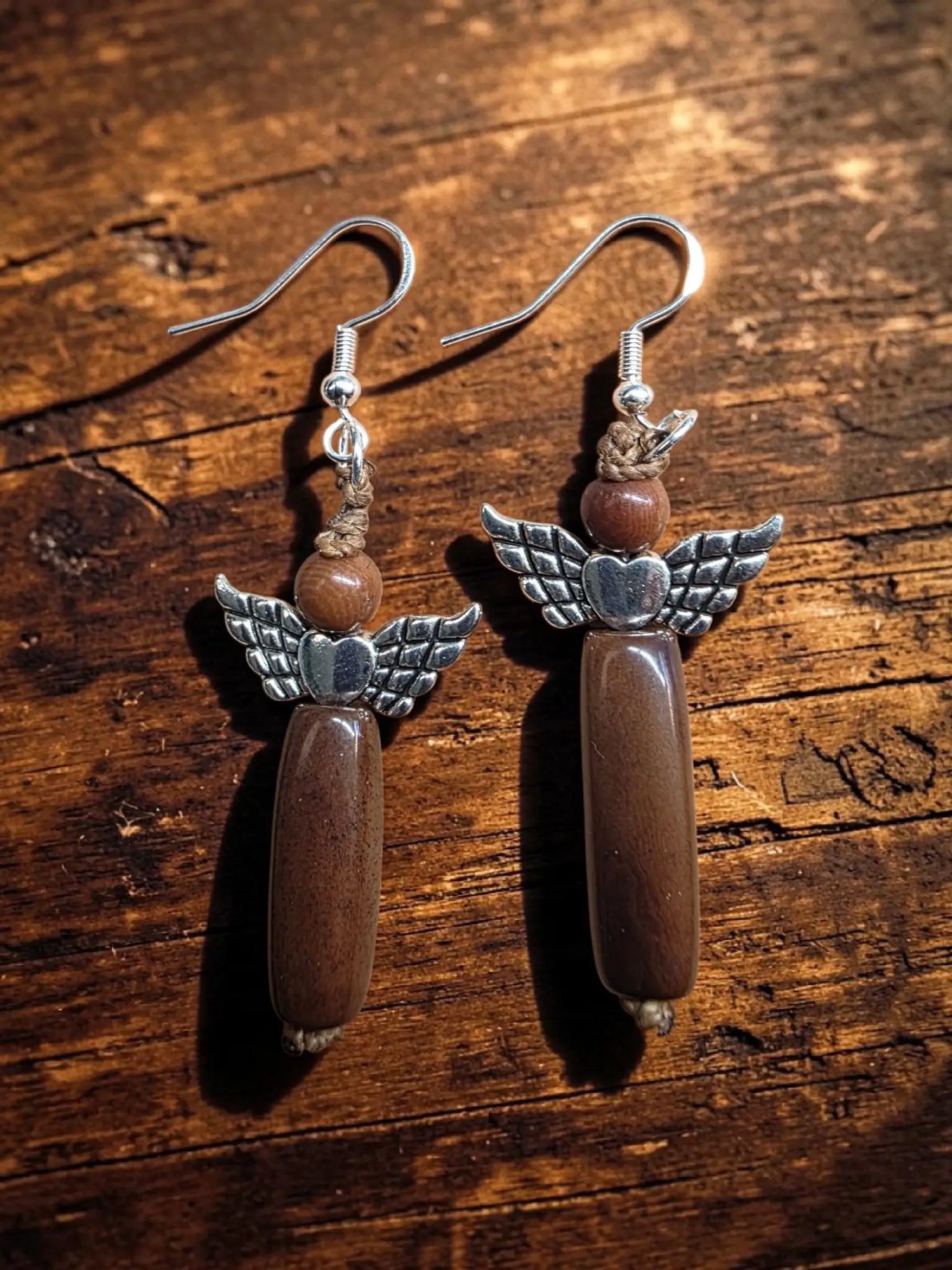 Silver angel earrings with detailed wings and heart featuring brown polished tagua carved vegetable ivory beads