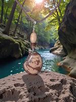 Camel tan brown natural live edge tagua mixed media pendant with swirling patterns on a handmade braided leather cord