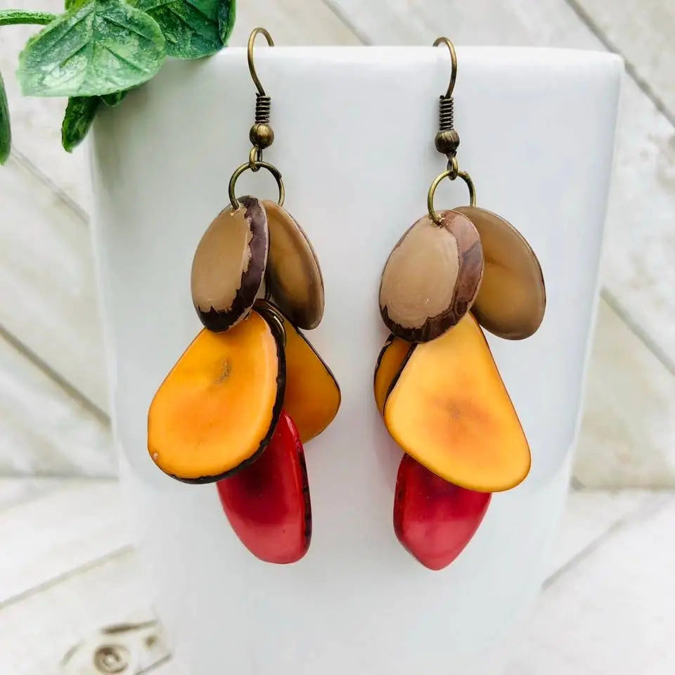 A pair of cascada earrings with layered oval pieces in tan mustard and watermelon tones with a polished finish