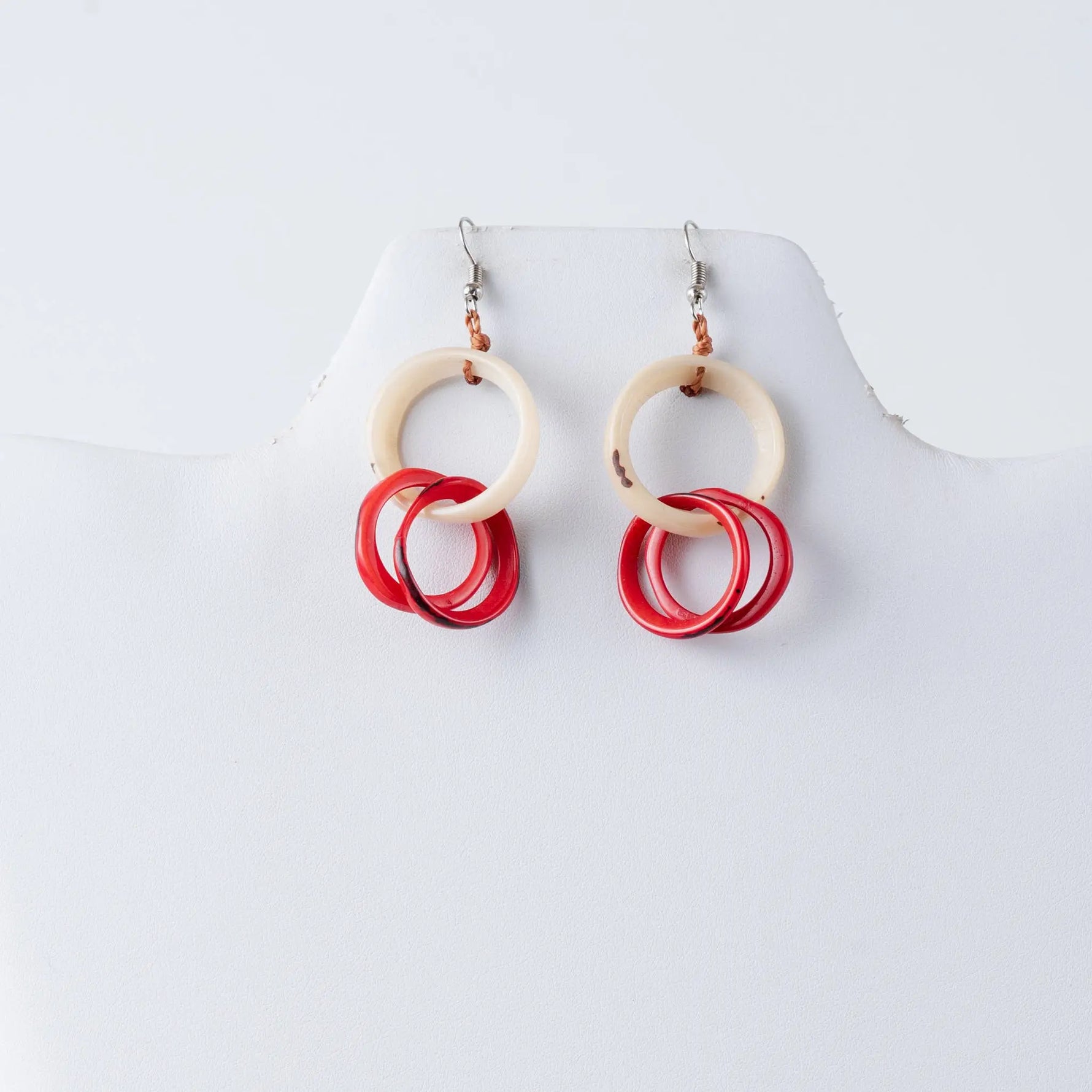 Catalina circular tagua earrings with cream top ring and three overlapping red circles on silver fishhook clasps