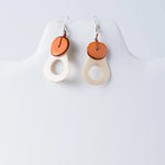 Charli geometric tagua earrings cream teardrop shape with warm orange circular accent on top