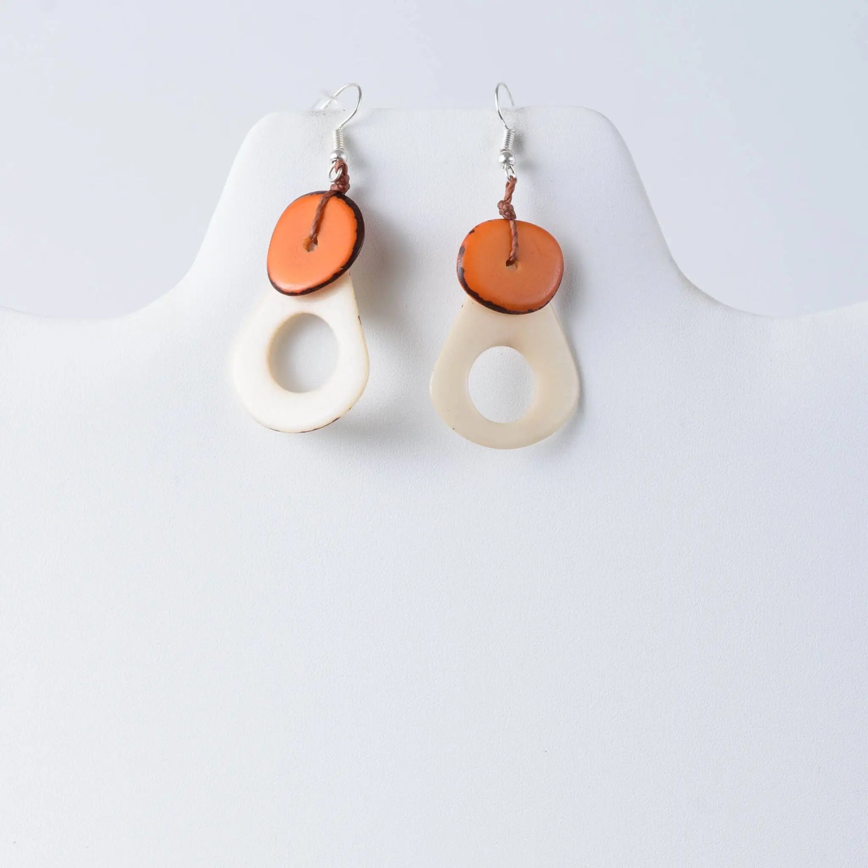 Charli geometric tagua earrings cream teardrop shape with warm orange circular accent on top
