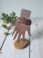 Chocolate brown carved tagua nut forest seed bracelet with smooth segments displayed on a wooden hand stand