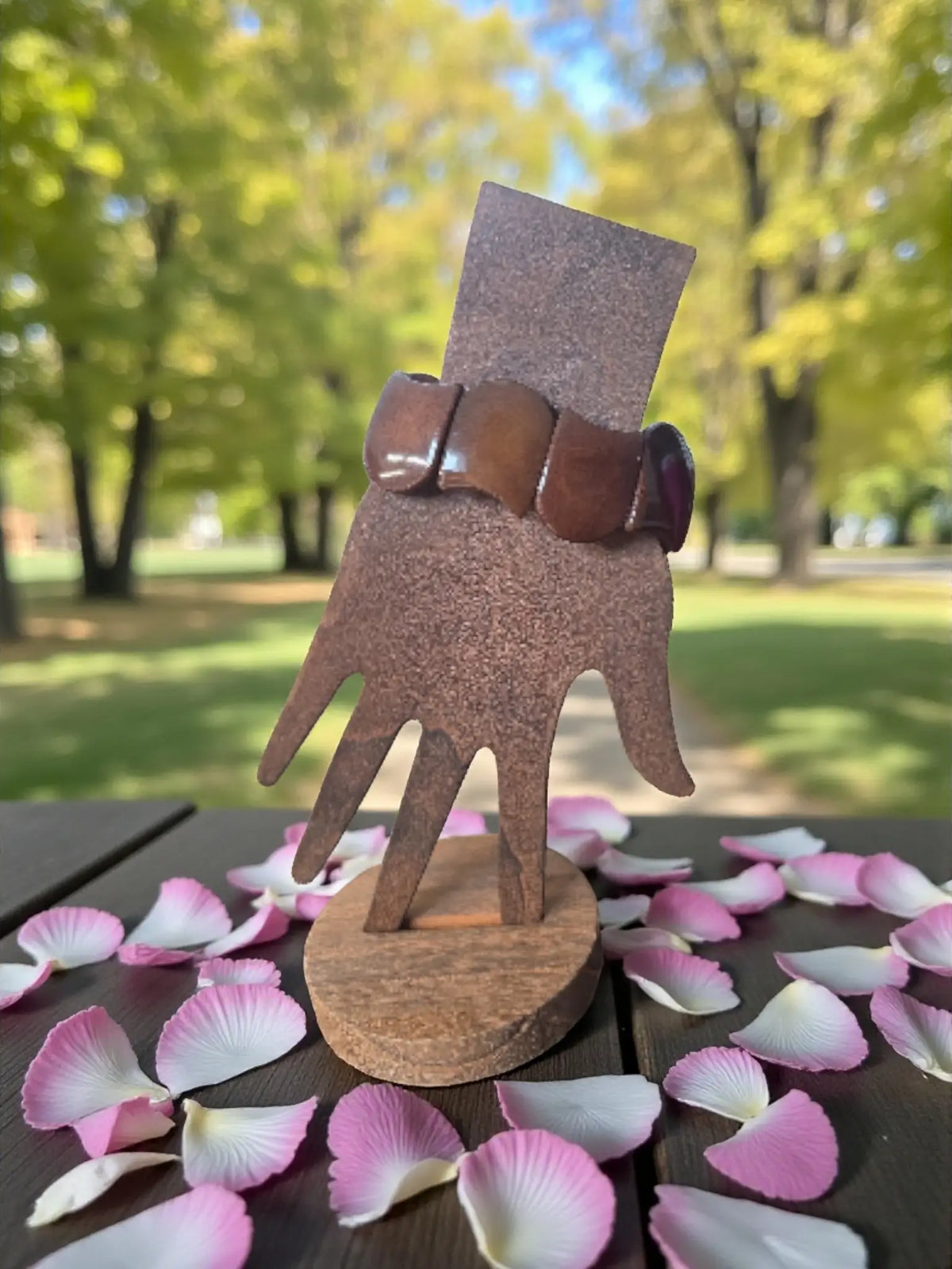 Brown wooden hand display stand holding a chocolate brown carved tagua nut seed bracelet forest seed bracelets