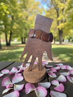 Brown wooden hand display stand holding a chocolate brown carved tagua nut seed bracelet forest seed bracelets
