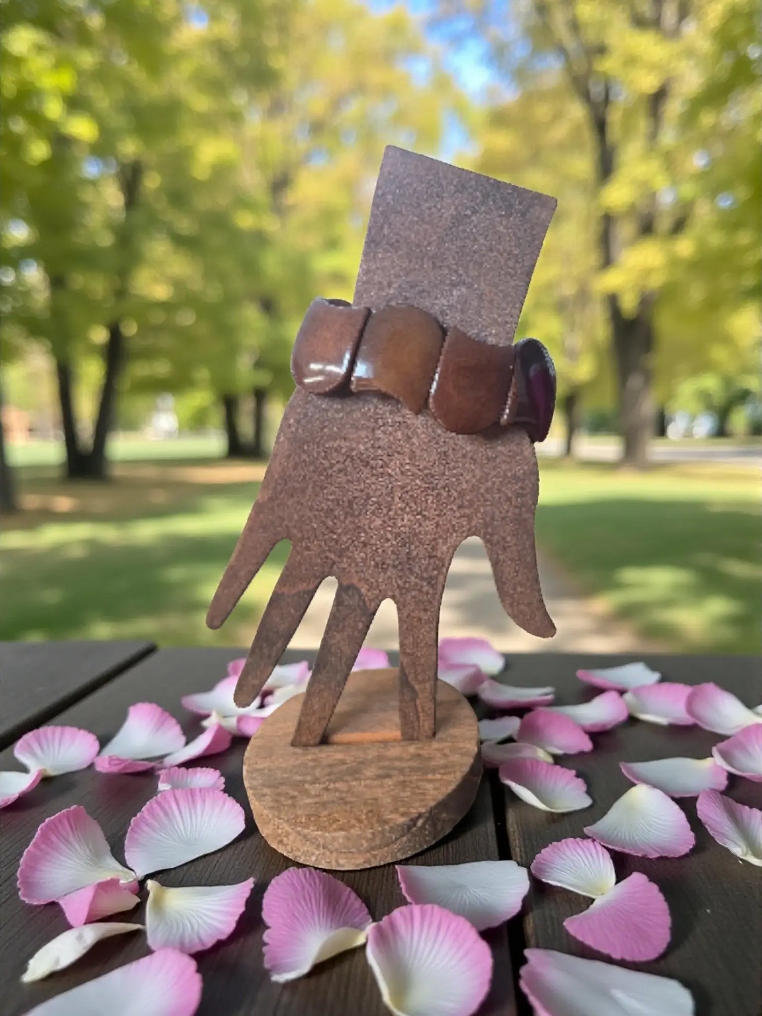 Brown wooden hand display stand holding a chocolate brown carved tagua nut seed bracelet forest seed bracelets