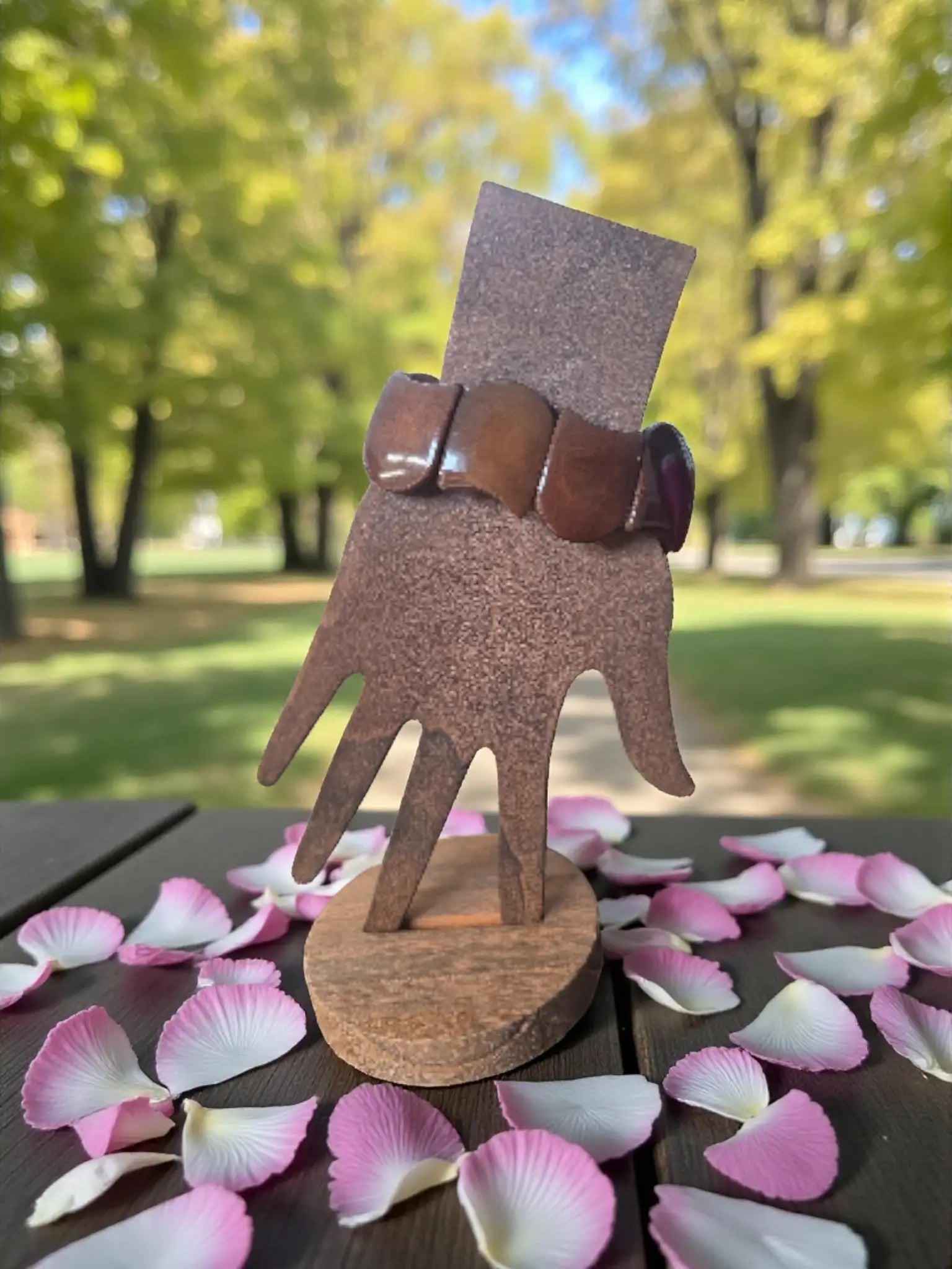 Brown wooden hand display stand holding a chocolate brown carved tagua nut seed bracelet forest seed bracelets