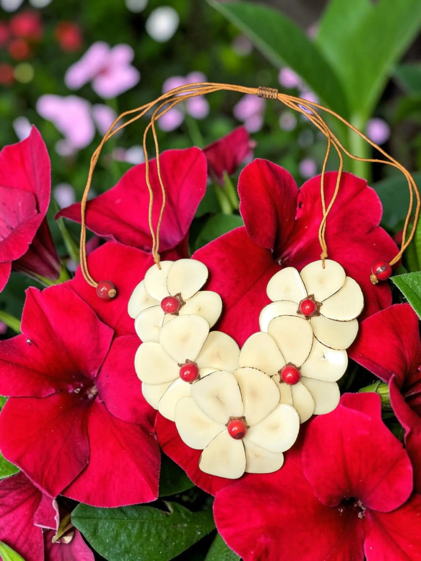Cream ivory carved tagua chips flower bib necklace with red bead accents and natural tan cord slider by becca