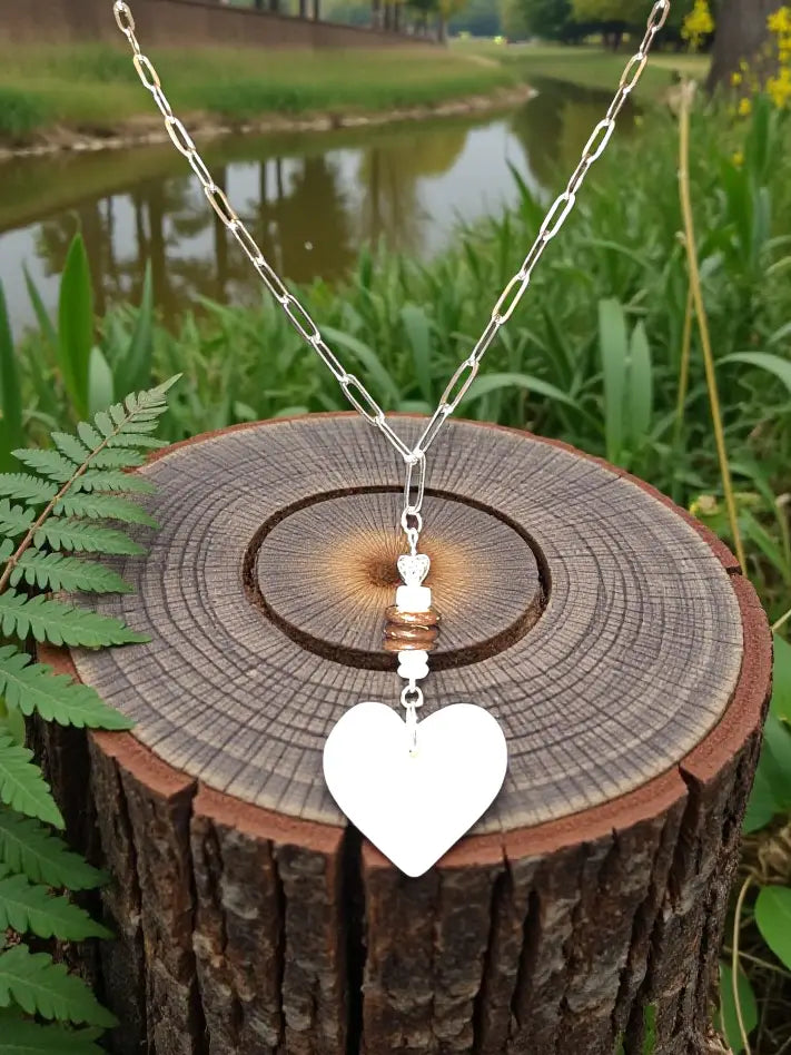 Silver chain pendant necklace featuring a cream white carved heart lightweight tagua with copper-toned accents