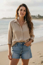 Beige linen button-down shirt with rolled sleeves paired with dove gray polished tagua slice earrings featuring glass bead mix