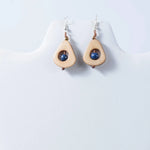 Beige teardrop eco friendly tagua earrings with a central blue bead and copper toned accents from eden collection