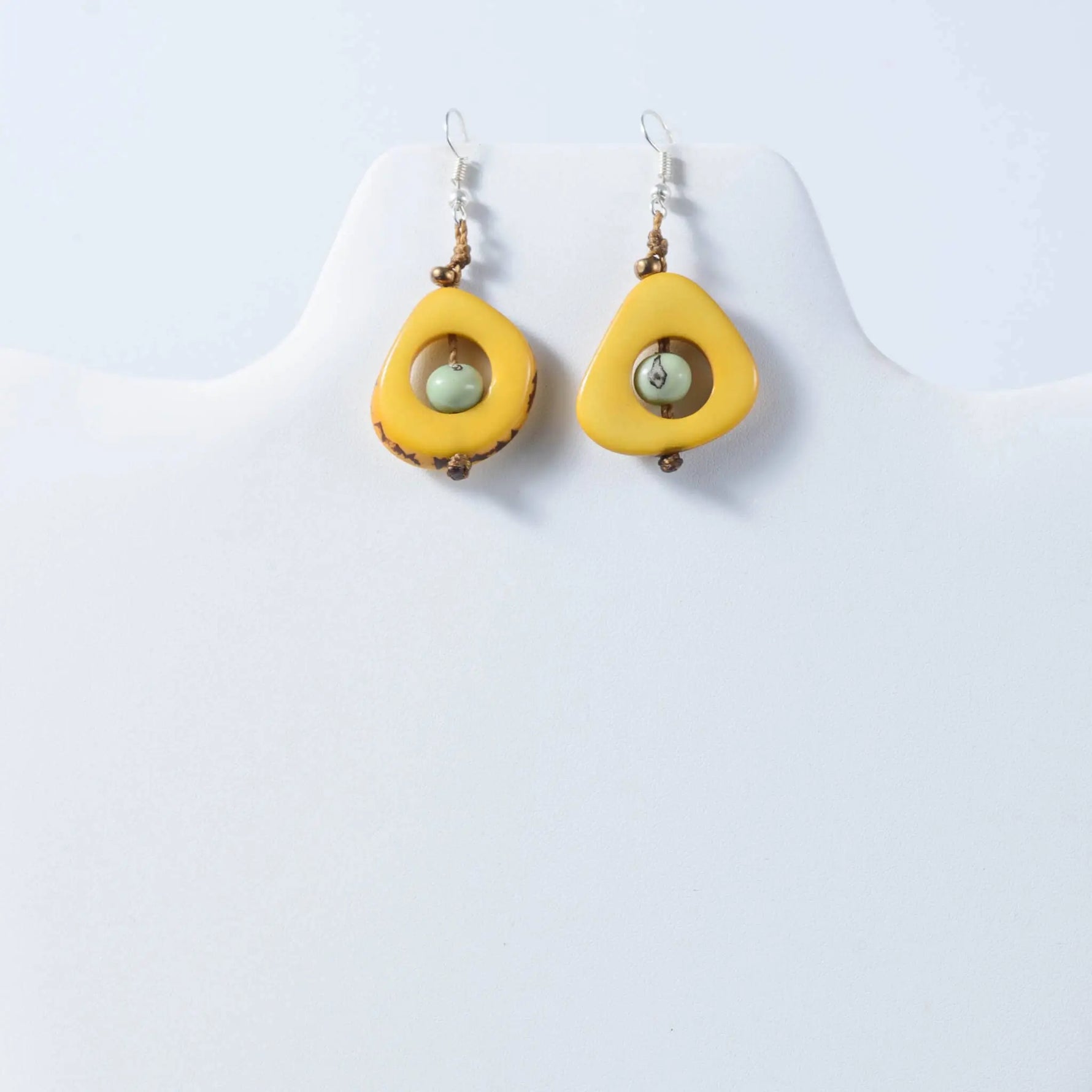Eden teardrop eco-friendly earrings with bright yellow tagua, light green bead, and brown accents