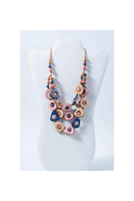 A colorful eden three stranded tagua necklace with pink blue beige teardrop beads and gold accents