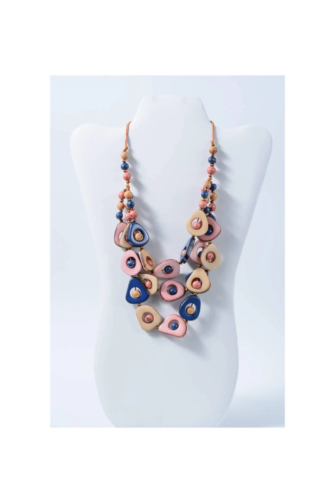 A colorful eden three stranded tagua necklace with pink blue beige teardrop beads and gold accents