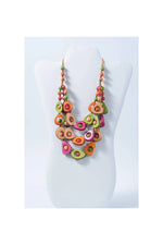A vibrant eden three stranded tagua necklace with handcrafted green orange and pink avocado pendants and small beads