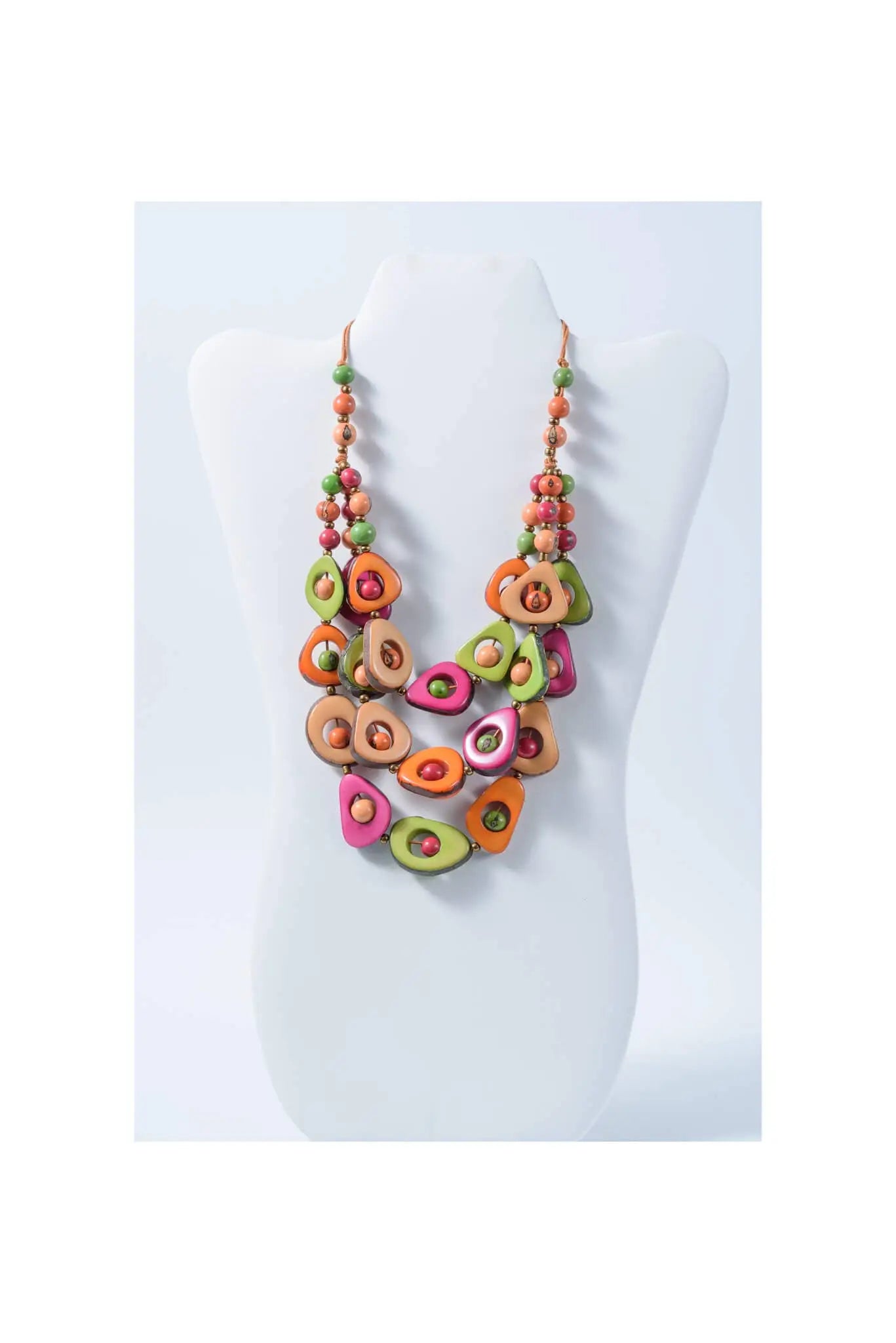 A vibrant eden three stranded tagua necklace with handcrafted green orange and pink avocado pendants and small beads