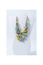 Eden three stranded tagua necklace with vibrant turquoise yellow and beige beads and metallic accents
