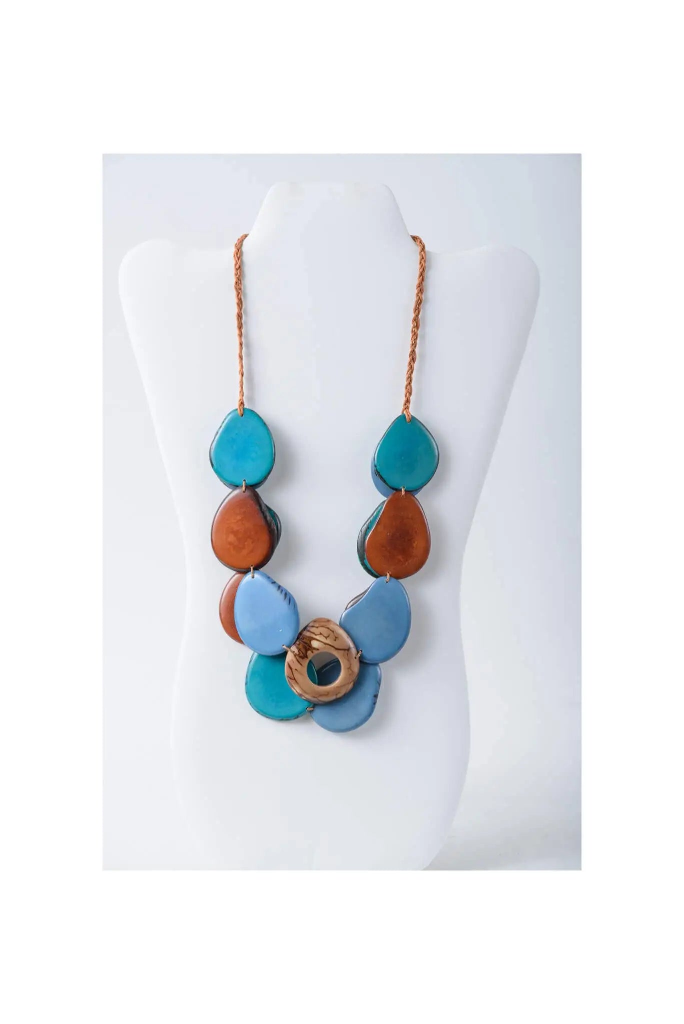 Ella layered tagua slice necklace with vibrant blue pink and brown teardrop beads and a pink patterned center ring