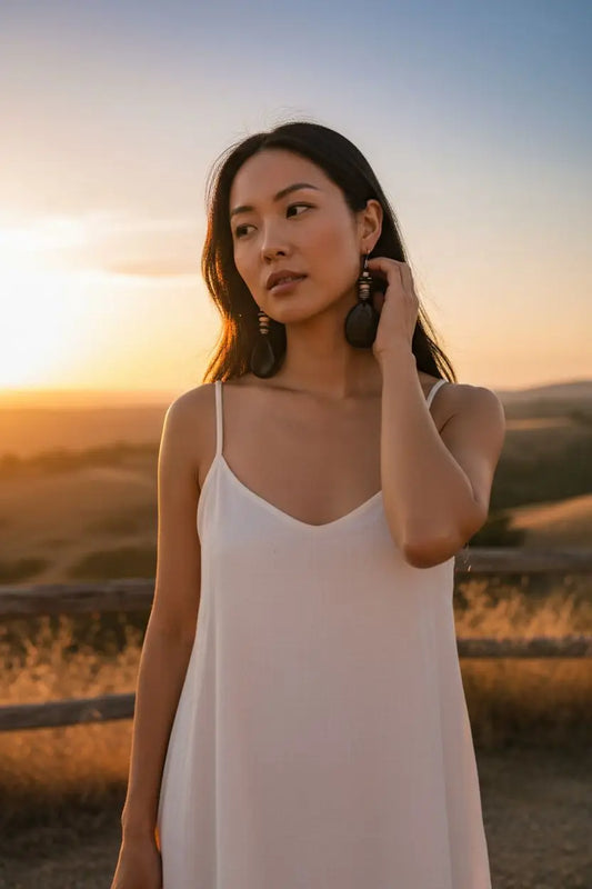 White spaghetti strap dress paired with favorite black ghost swirl engraved earrings for stylish look