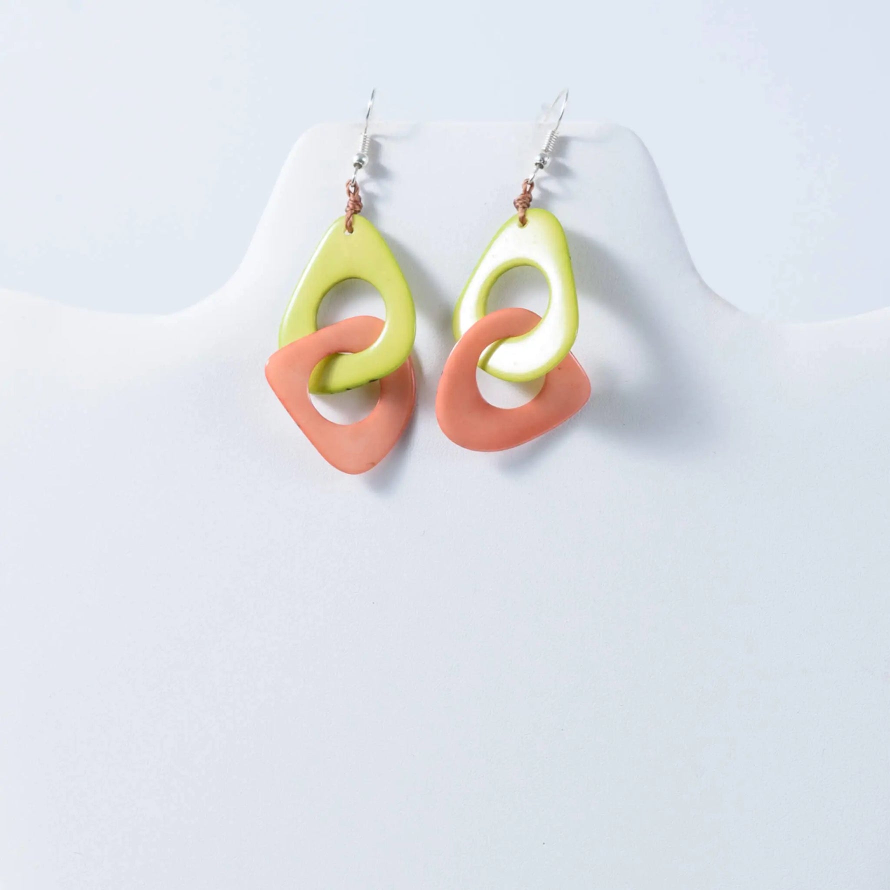 Fern interlocking tagua earrings featuring lime green and coral resin drops with a modern ring design