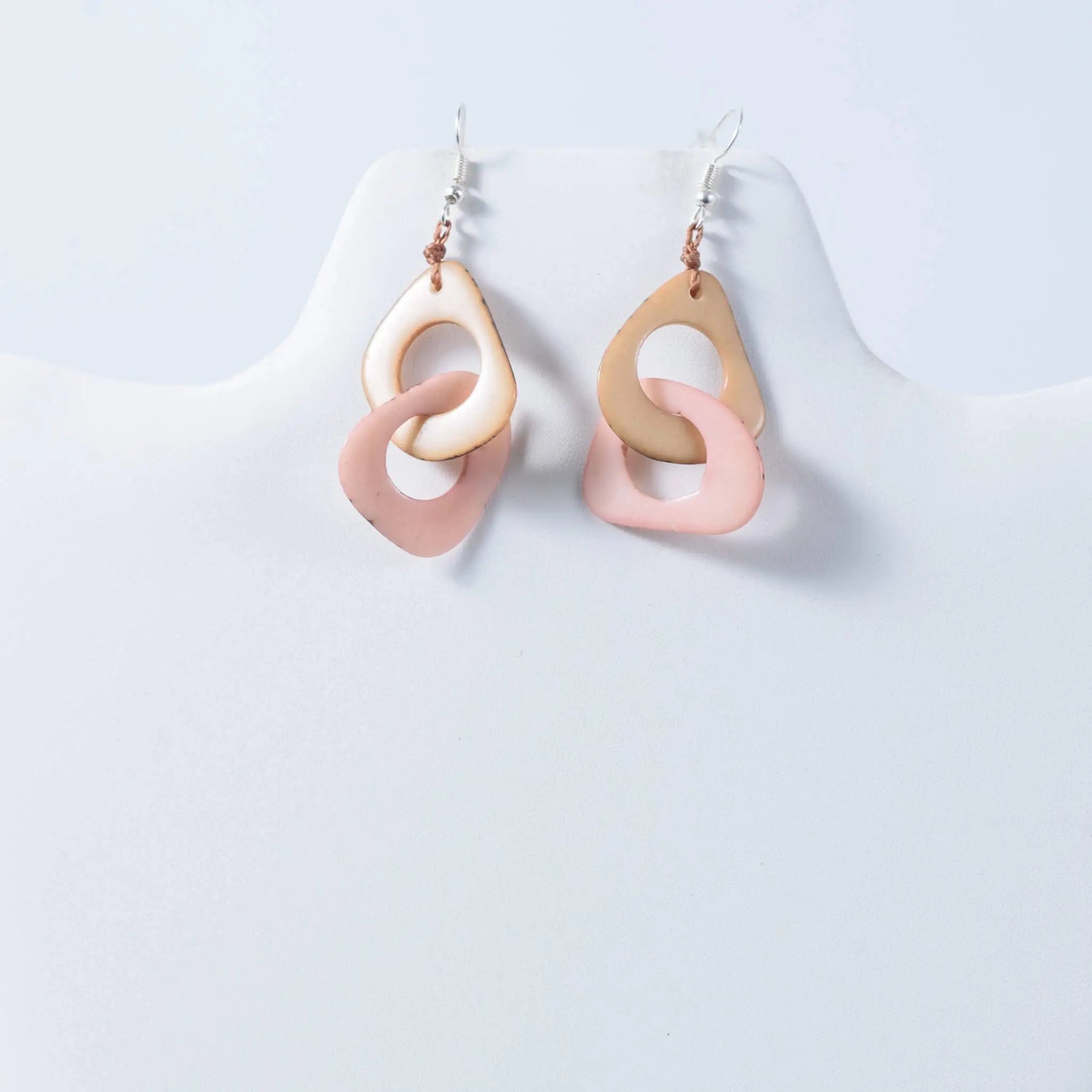 Pastel pink and beige resin drop fern interlocking tagua earrings with a modern ring design