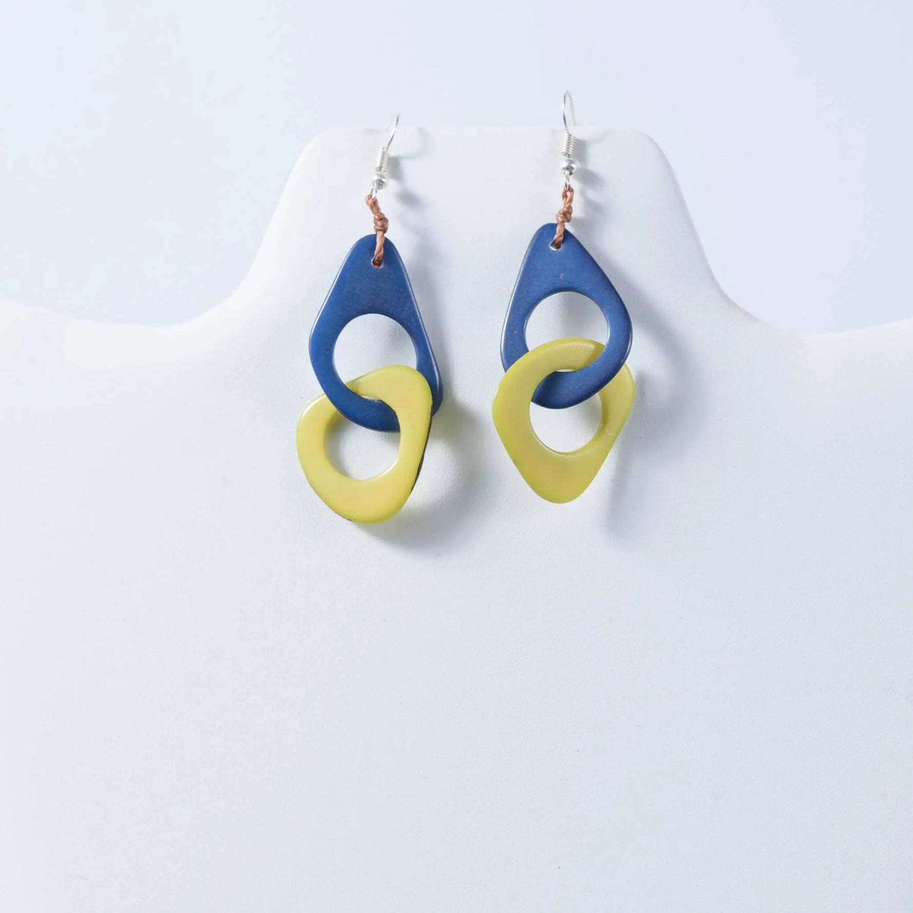Fern interlocking tagua earrings with blue and yellow geometric drop design made from natural tagua material