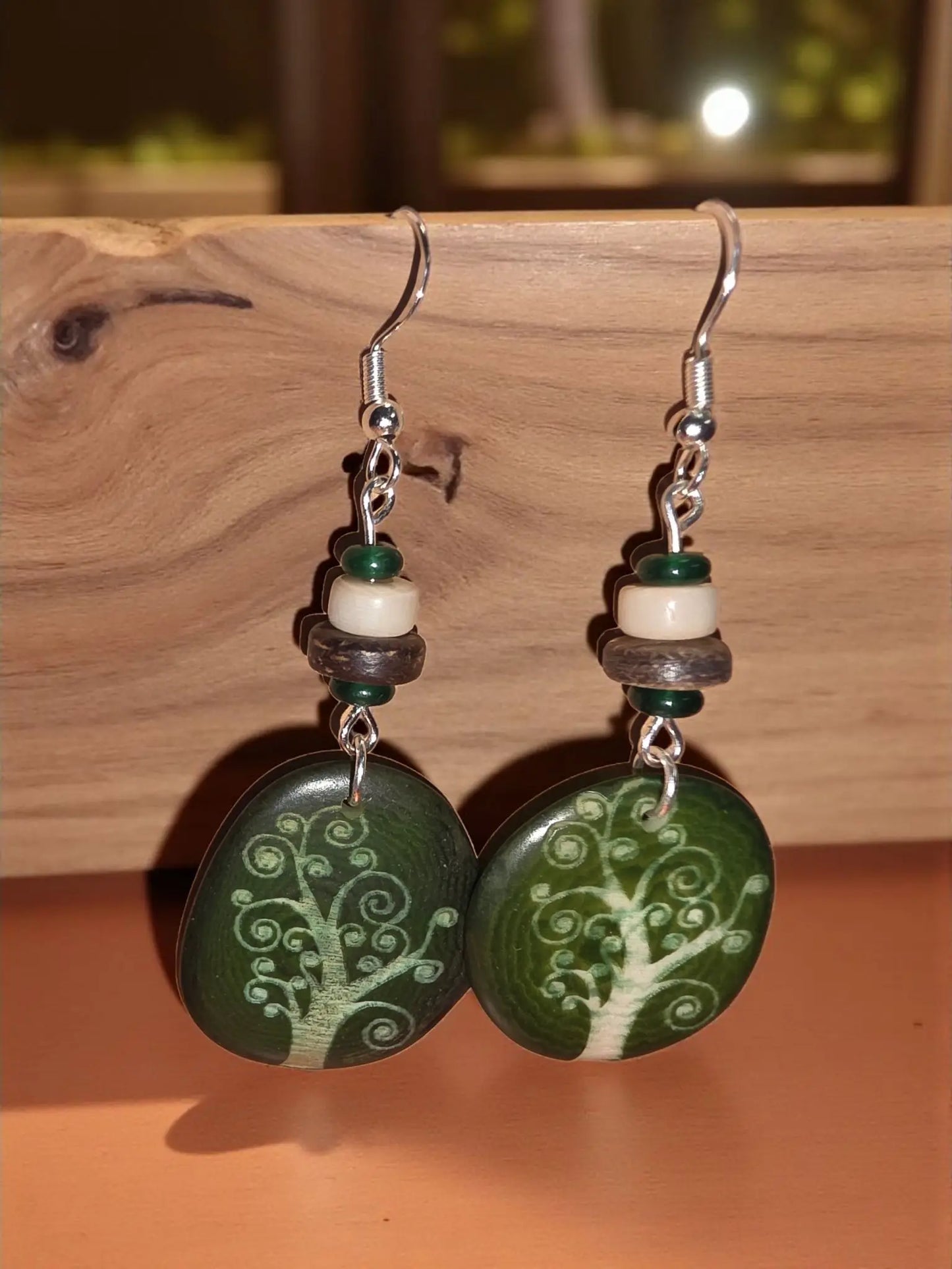Forest green tree-of-life pendant earrings with silver hooks and layered tags made from laser engraved tagua slices