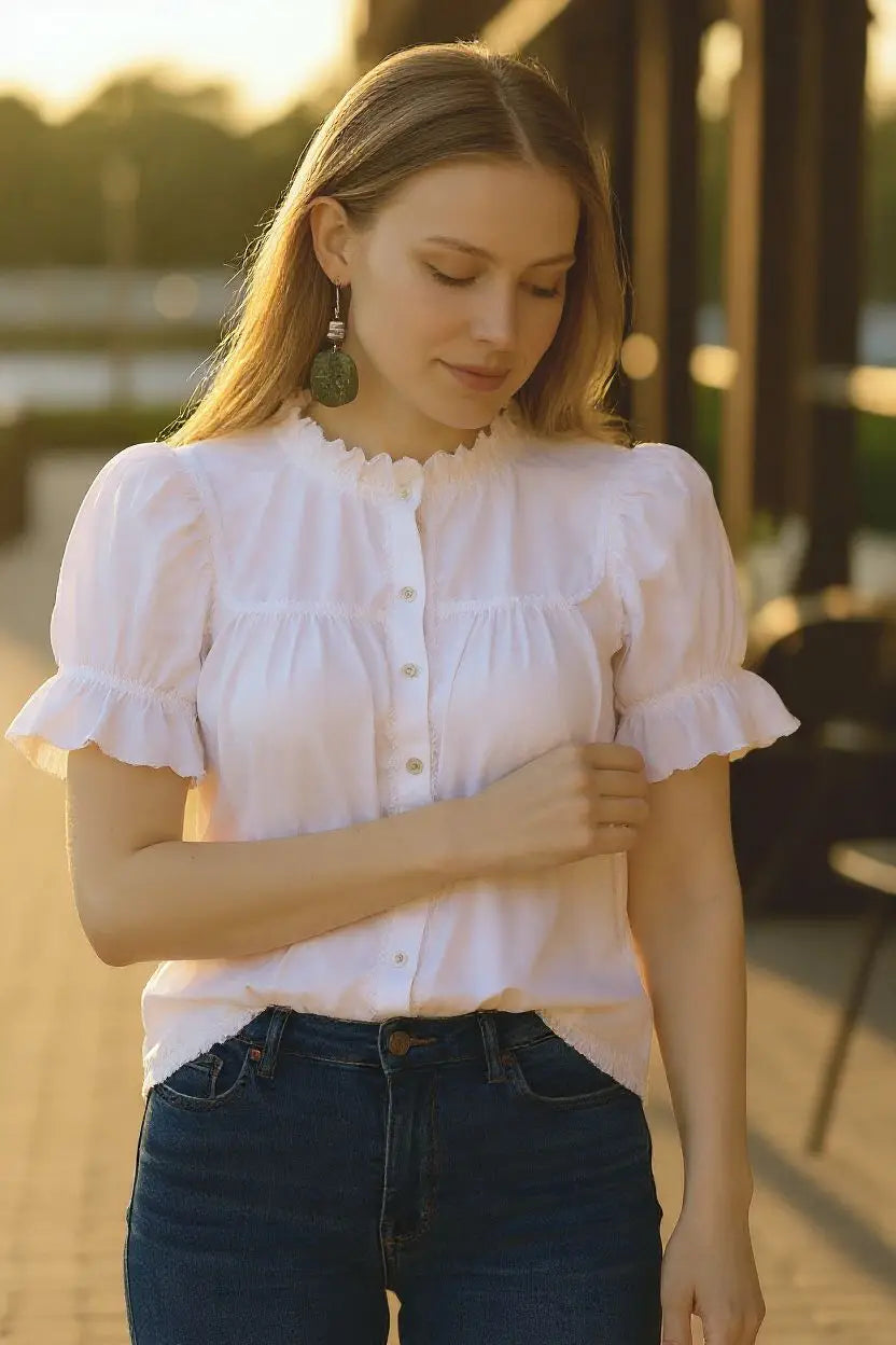 White blouse with ruffled sleeves and scalloped neckline paired with forest green swirly tree laser engraved tagua slice earrings