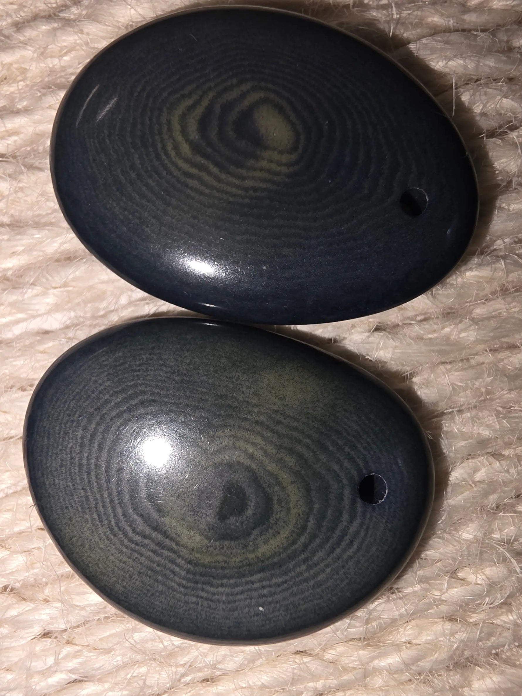 Forest green thick slice tagua earrings with polished dark blue oval stones and swirling greenish patterns with holes
