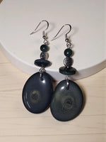 Forest green thick slice tagua earrings with dark blue oval shapes and swirling gray patterns with silver hooks
