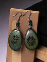 Green jade forest sunburst laser cutout flower tagua slice earrings with intricate floral cutouts and silver hooks
