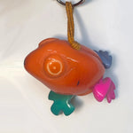 Glossy orange fish-shaped hand-carved tagua animal keychain with colorful pink teal and purple fins from rainforest friends