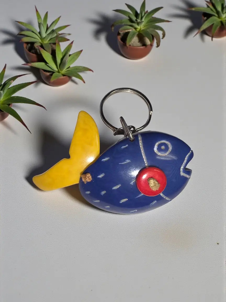 Blue hand-carved tagua animal keychain shaped like a fish with yellow tail red eye and white painted details