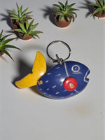Blue hand-carved tagua animal keychain shaped like a fish with yellow tail red eye and white painted details