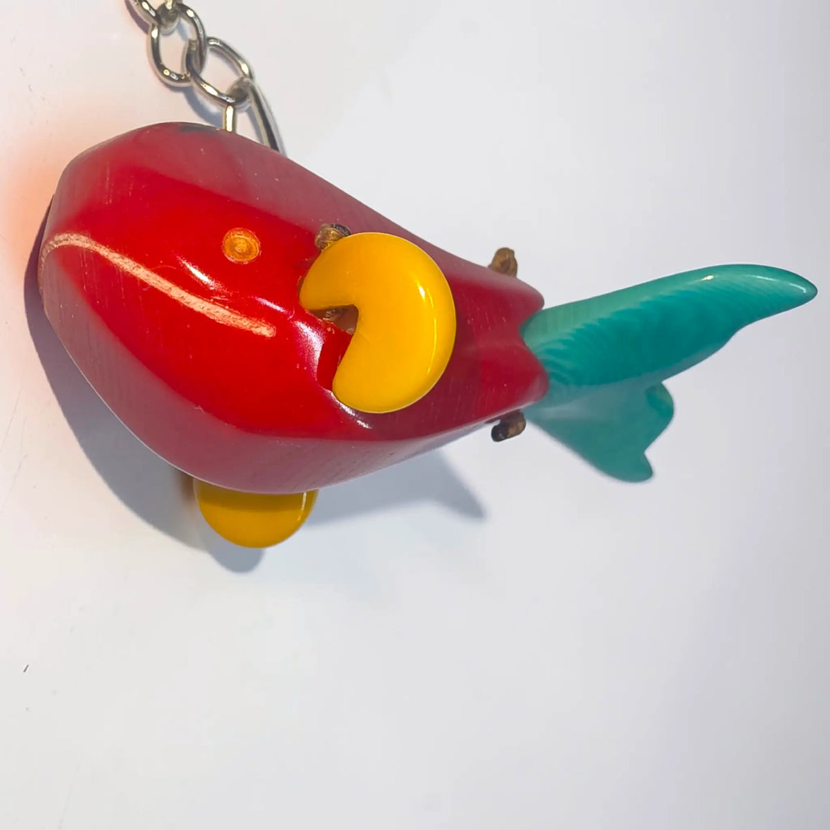 Vibrant red hand-carved tagua animal keychain shaped like a goldfish with yellow eyes and teal fins from rainforest friends