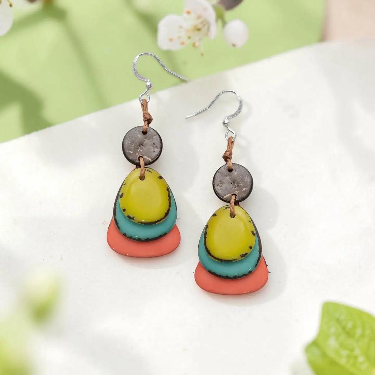 Graduated layers of tagua nut lightweight maia earrings with yellow teal coral discs and dark brown circular top piece