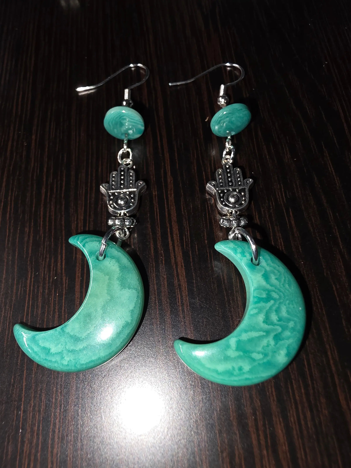Teal green moon carved crescent earrings with silver hamsa charms and smooth marbled carved tagua nut beads