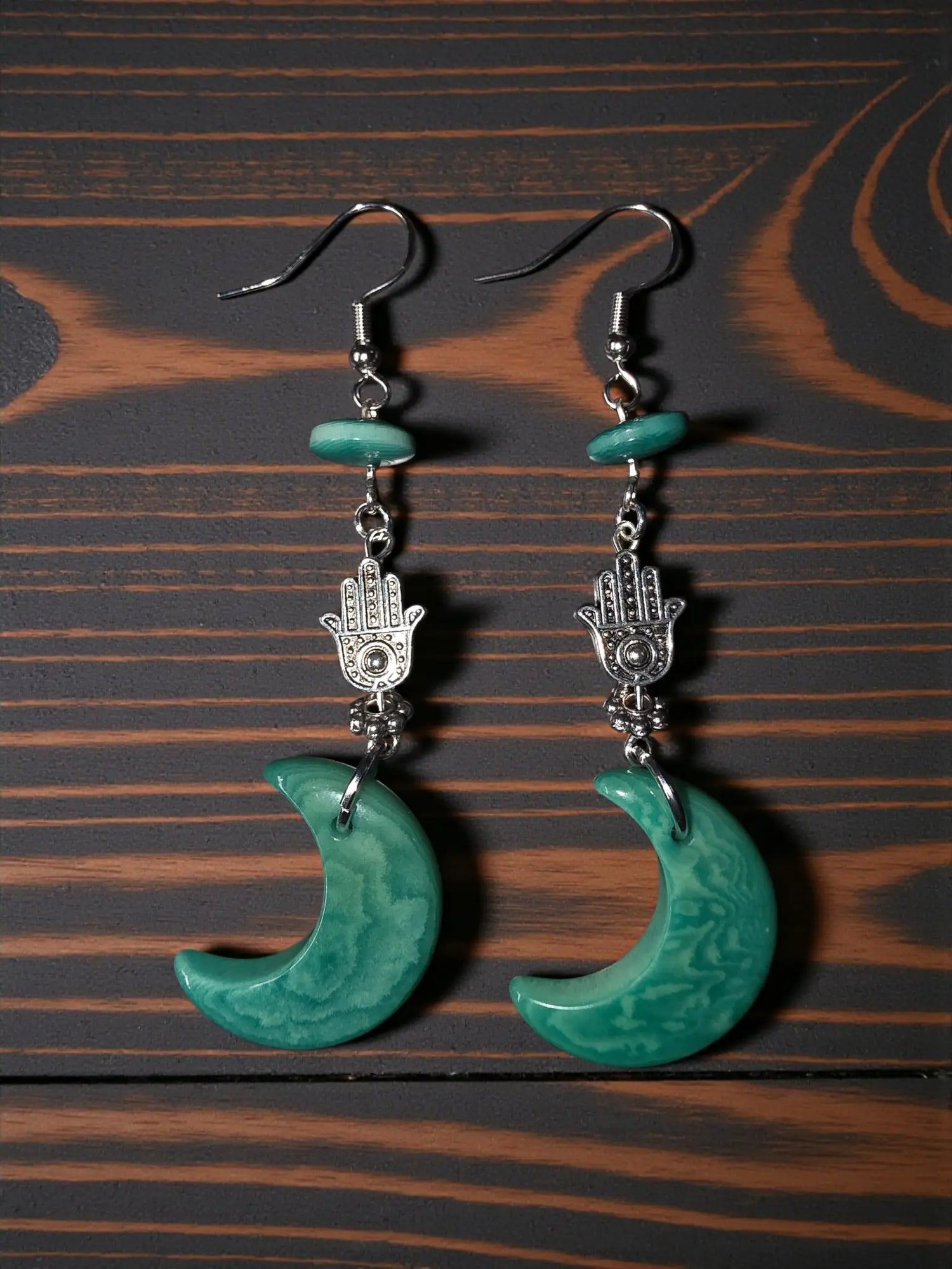 Teal green moon carved tagua nut earrings with silver hamsa hand charms and small turquoise beads