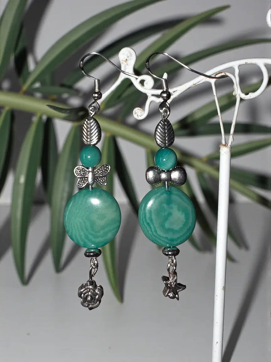 Teal-green agate bead rainforest tagua nut earrings with silver-toned metal accents and floral charms purposely mismatched
