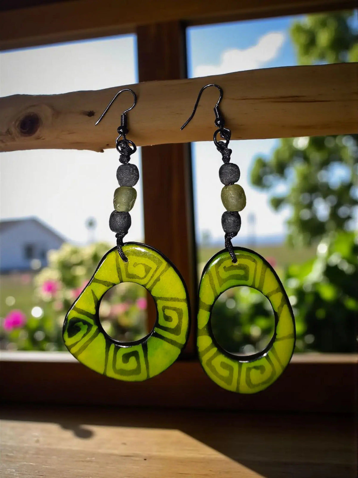 Hand-painted bold deco green with envy earrings are vibrant lime green circular earrings with black greek key pattern and dark gray beads