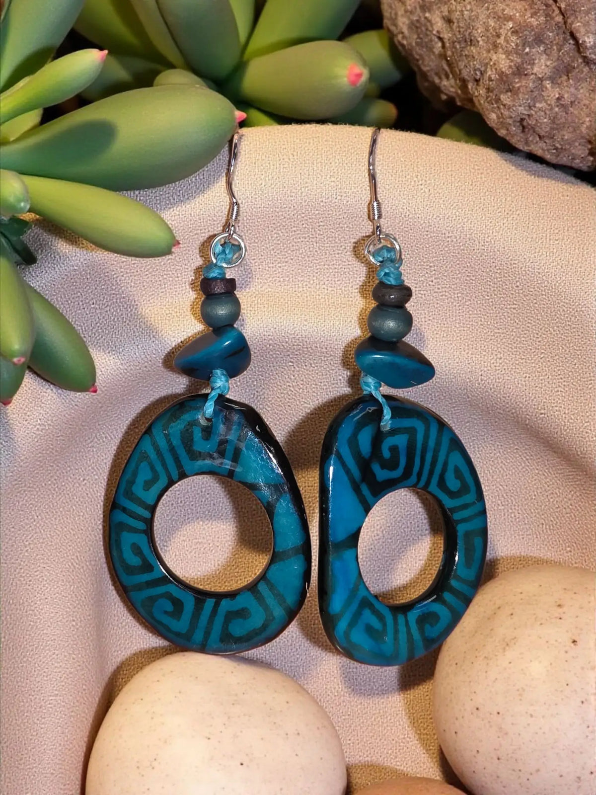 Hand-painted bold deco teal tagua hoop earrings with teal and black geometric pattern and turquoise beaded silver hooks