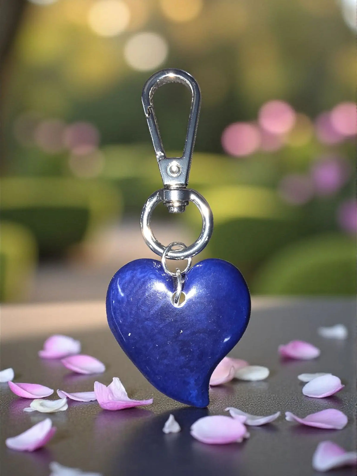 A glossy cobalt blue heart keychain with silver carabiner clip perfect as a stylish bag charm accessory